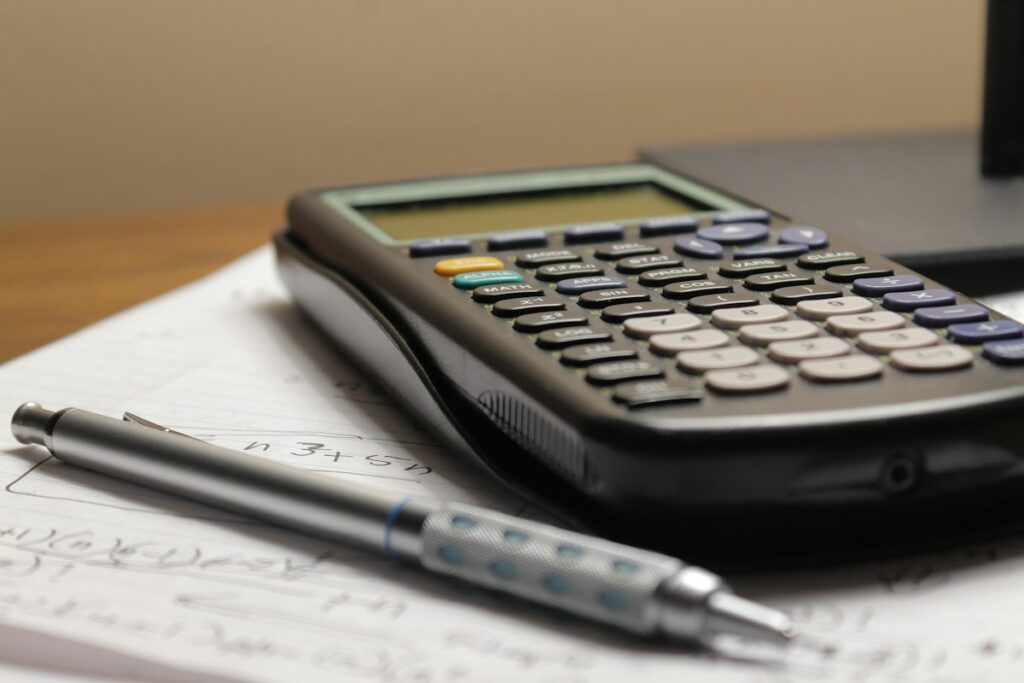 Calculator and pen on paper for comparing web hosting prices