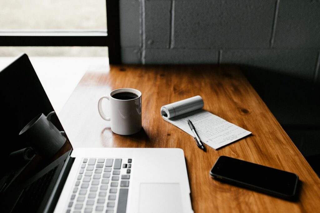 Laptop and notebook on a desk for a WordPress hosting checklist